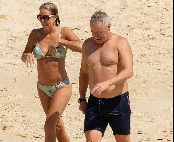 Guess who? Nineties heartthrob strips off and enjoys some fun in the sun with new partner who bears a striking resemblance to his long-term ex